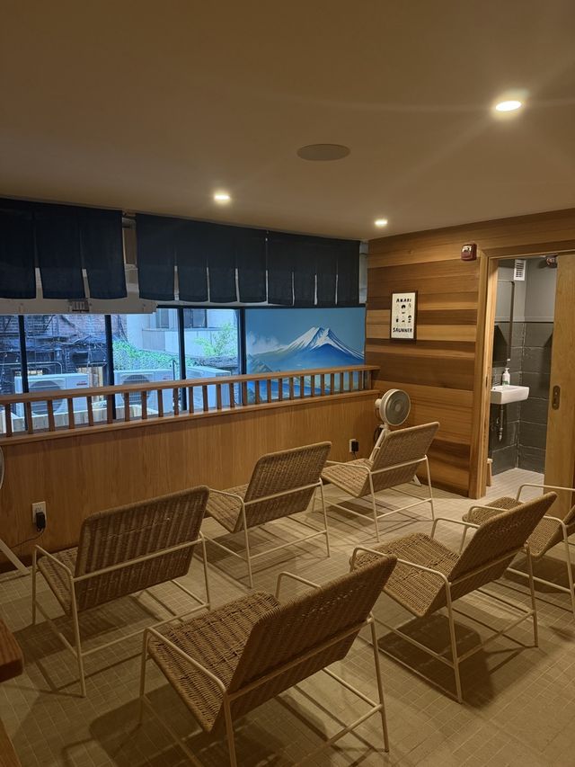 Wicker lounge chairs and a Mt. Fuji mural in the relax room at Akari